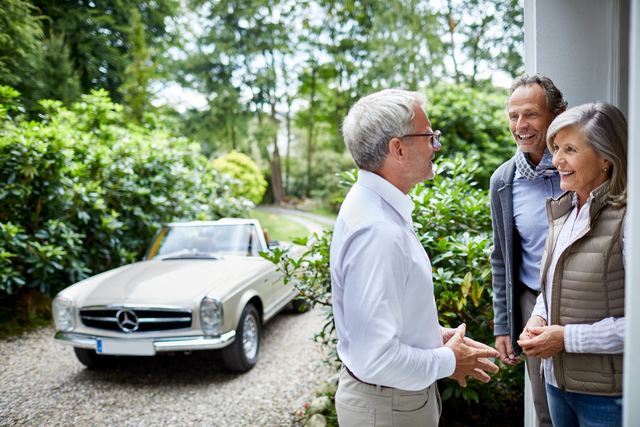 Gespräch im Garten vor einem Oldtimer